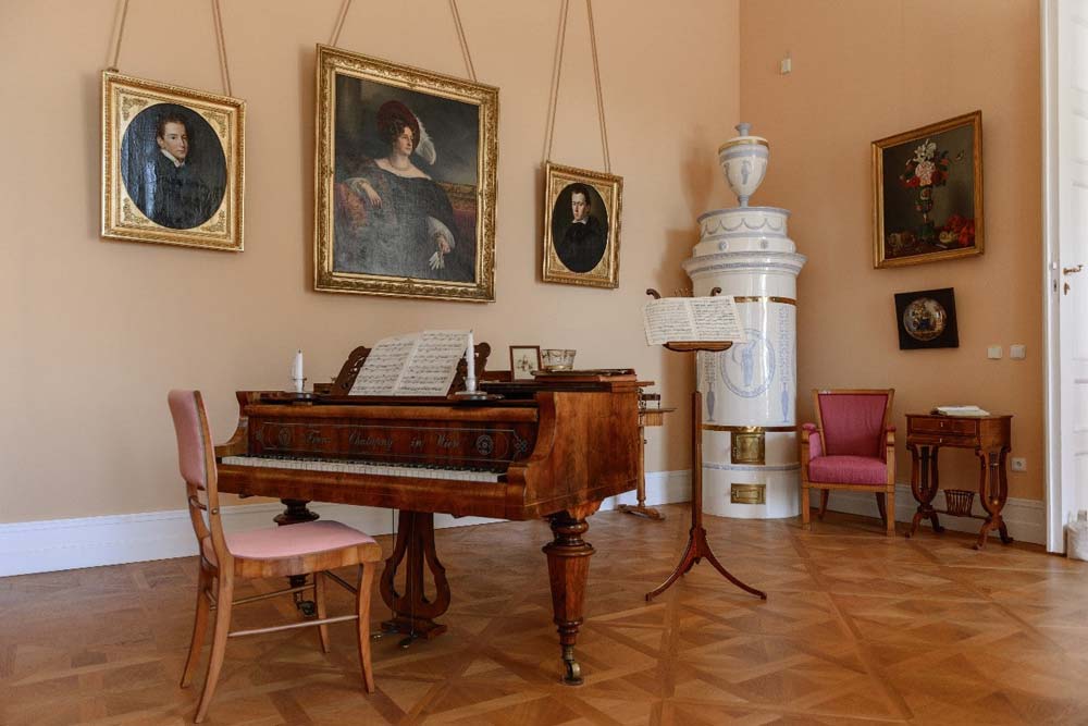 Nowy Pałac Kostelec nad Orlicí – wnętrze z fortepianem i obrazami