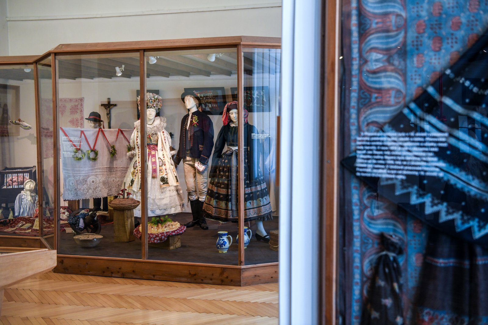 Ekspozycja w Muzeum Jana Amosa Komenského w Přerovie przedstawiająca tradycyjne stroje ludowe w przeszklonych gablotach.