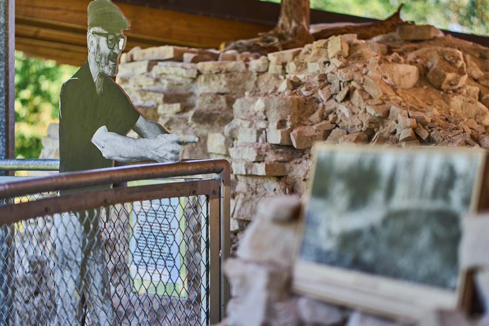 Zamek Vizmburk – ekspozycja archeologiczna z sylwetką badacza na tle odsłoniętych murów średniowiecznego zamku.