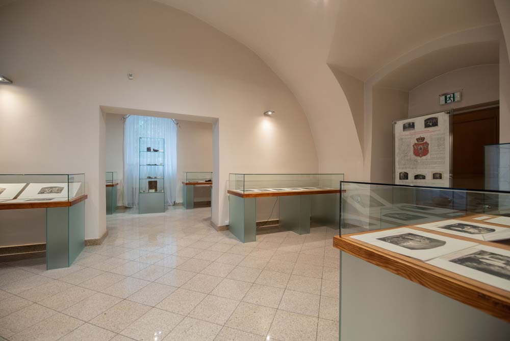 Wystawowa sala pod sklepieniem kolebkowym – gabloty ze starodrukami i grafikami oraz plansze informacyjne w zamku w Rogowie Opolskim.