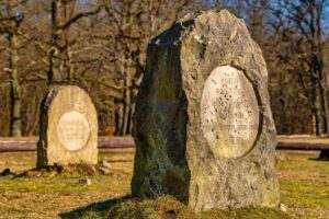 Kamienny nagrobek na cmentarzu koni w Kliczkowie i drugi pomnik w tle