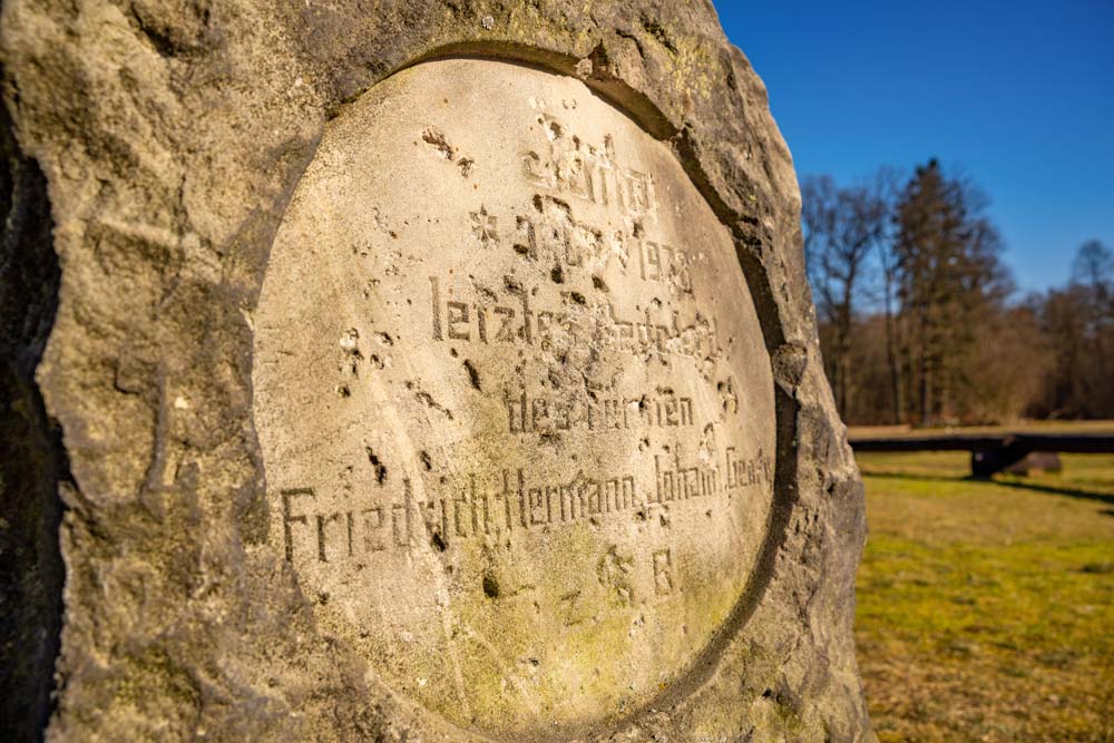 Zbliżenie na zniszczoną inskrypcję historycznego nagrobka na cmentarzu koni w Kliczkowie