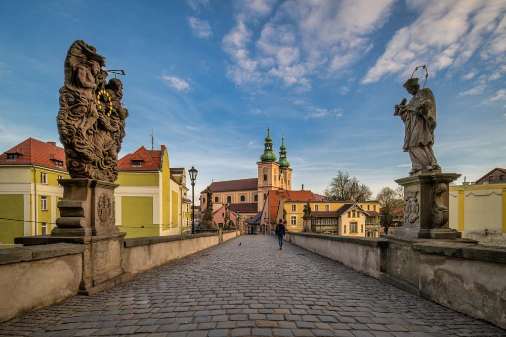 Spacer po Moście Św. Jana w Kłodzku między barokowymi figurami i widokiem na starówkę
