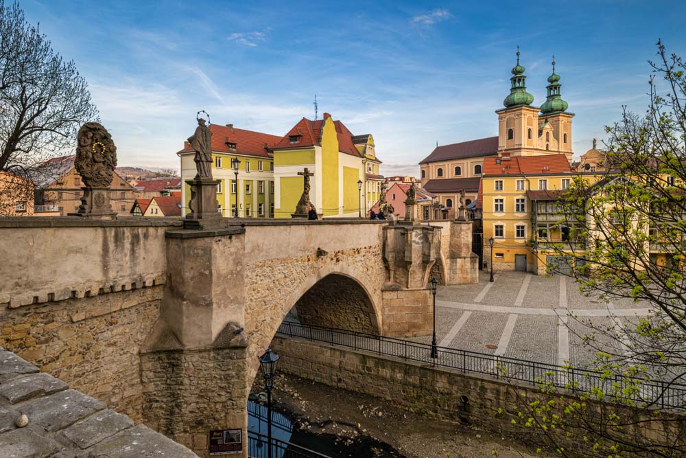 Kamienny Most Św. Jana w Kłodzku i barokowe figury świętych na tle kościoła oraz starówki